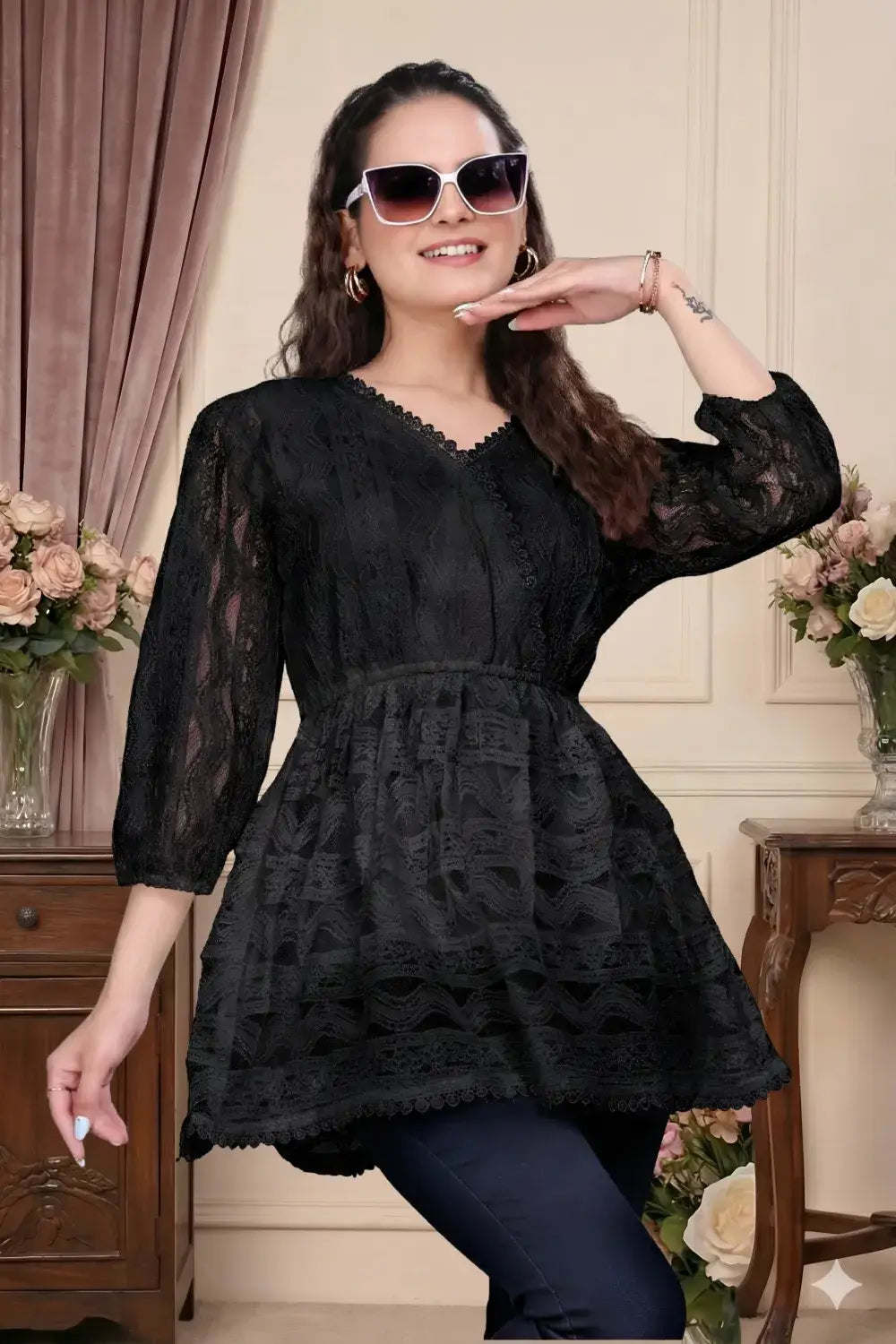 Woman wearing a black lace dress indoors with decorative elements.