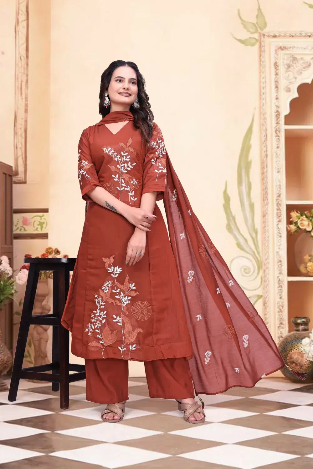Woman wearing a red embroidered traditional outfit in an indoor setting.