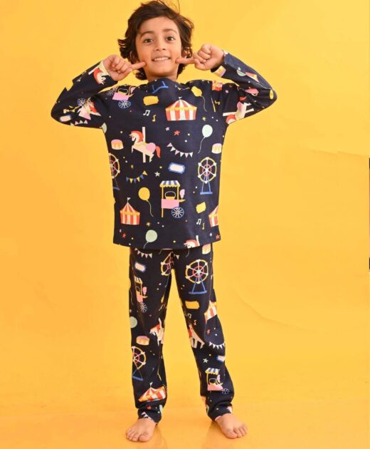 Child posing in a navy carnival-print long-sleeve top and matching pyjama trousers.