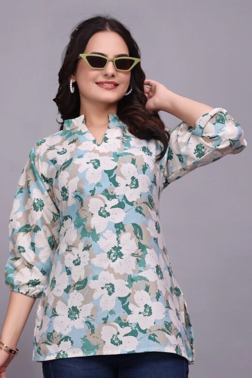Close-up of a teal and white floral tunic with a notched neckline and three-quarter sleeves.